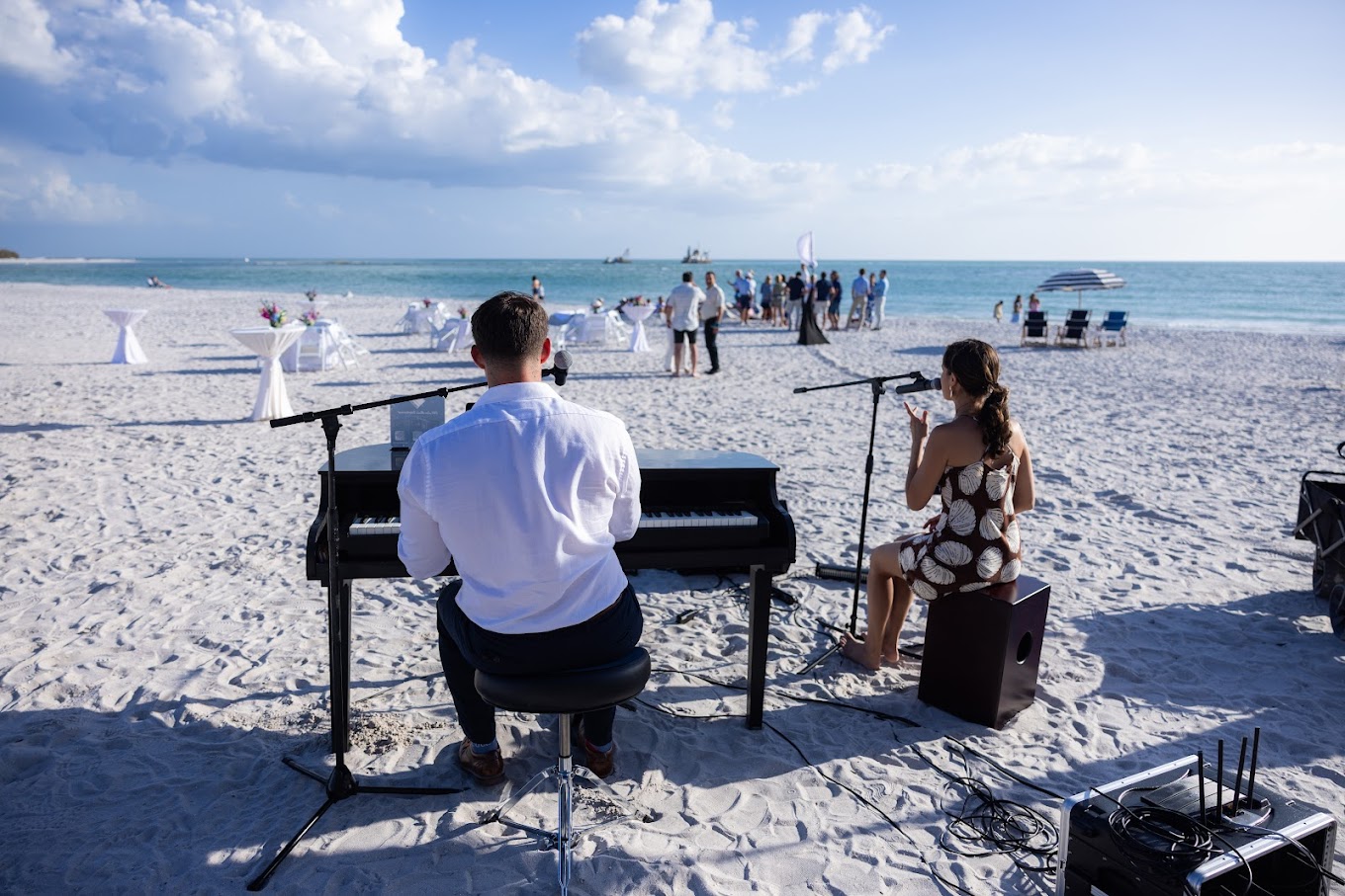 Chase and Esmeralda performing live music for a beachside celebration
