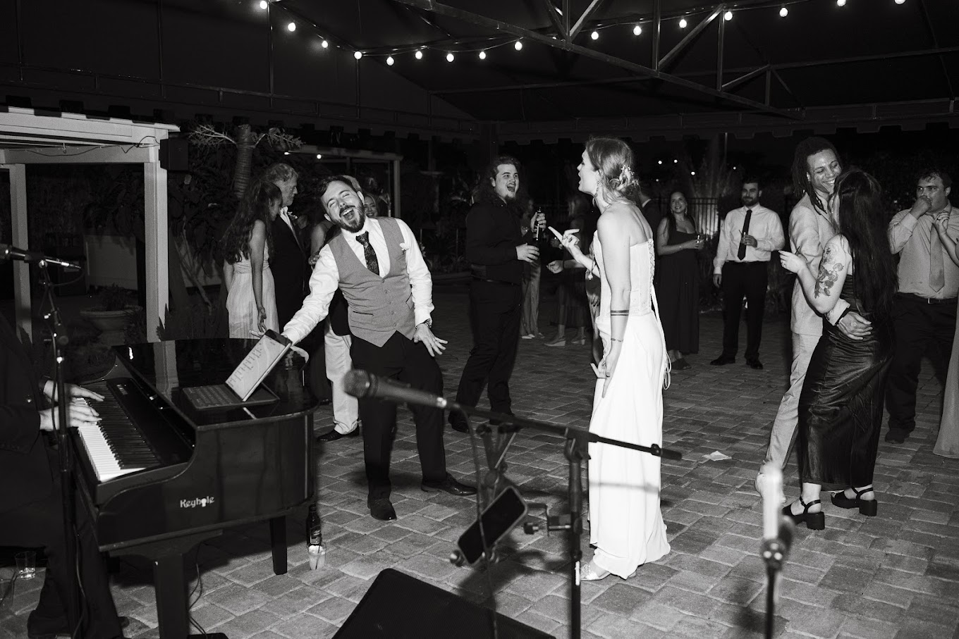 Wedding guests singing and celebrating beside the live piano